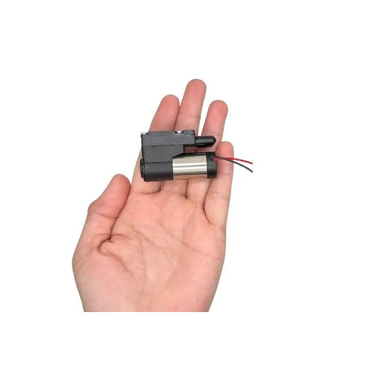 Hand holding OD-05T02.53000 mini diaphragm pump for size comparison