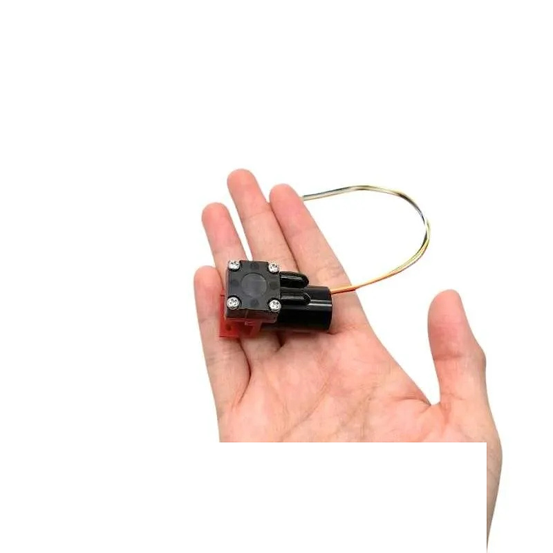 Hand holding OD-05T02500B Mini Diaphragm Pump for size reference